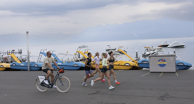 2025년 8월 19일 스위스 로잔에서 열린 아틀레티시마 로잔 다이아몬드리그를 앞두고 훈련 중인 영국의 킬리 호지킨슨(왼쪽)과 조지아 헌터 벨, 캐트리오나 비셋, 에단 매시를 트레버 페인터 코치(뒤)가 자전거를 타고 따라가며 지켜보고 있다. 게티이미지