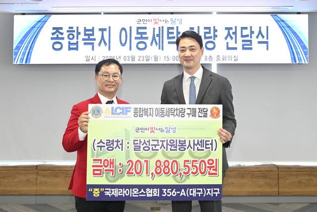(왼쪽)김경웅 국제라이온스협회 대구지구 총재가 최재훈 달성군수에게 이동세탁차량을 기증, 기념 촬영하고 있다. 달성군 제공