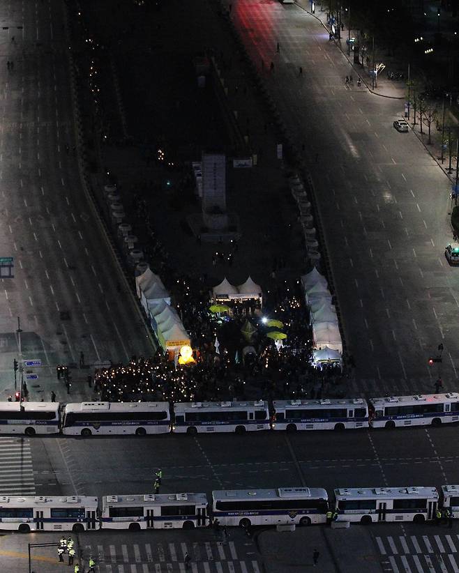 세월호 참사 1주기를 앞둔 2015년 4월 16일, 서울시청 광장에서 열린 ‘세월호 범국민 추모문화제’ 이후, 청와대를 향하던 시민들이 경찰 차벽에 가로막힌 가운데 일부 시민들이 이순신 장군 동상 앞에 설치된 세월호 분향소 천막에 모여있다. / 고운호 기자