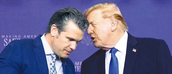 < 확전과 종전 사이, 어떤 결단 내릴까 > 미국이 이란 공격을 5일간 유예한다고 밝힌 가운데 도널드 트럼프 대통령이 23일(현지시간) 테네시주 멤피스 주방위공군기지에서 열린 공공안전회의에서 피터 헤그세스 전쟁부 장관과 대화하고 있다. AP연합뉴스