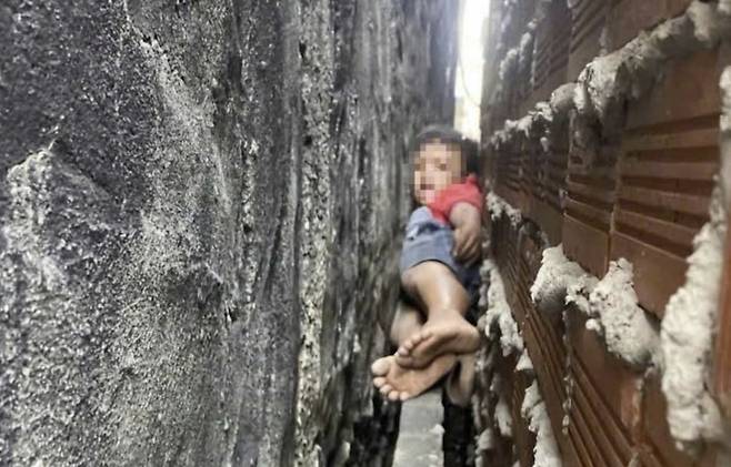 베트남 호찌민시 빈꺼 지역에 사는 9세 A군이 25일 오전 벽 사이에 낀 채 몸을 움직이지 못하고 있다. 사진=VN익스프레스 홈페이지 캡처
