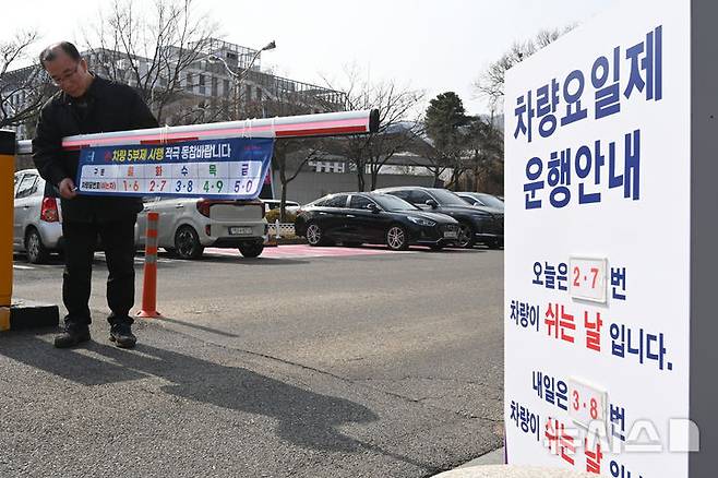 [군포=뉴시스] 김종택 기자 = 24일 경기 군포시청 주차장 입구에서 직원들이 내일부터 시행하는 차량 5부제를 앞두고 안내문을 설치하고 있다. 정부는 중동 사태로 원유 수급 위기가 확산되자 내일부터 공공부문에 대한 승용차 5부제를 시행한다. 2026.03.24. jtk@newsis.com