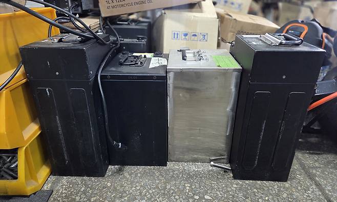 전기이륜차에서 분리한 배터리가 바닥에 놓여있다.