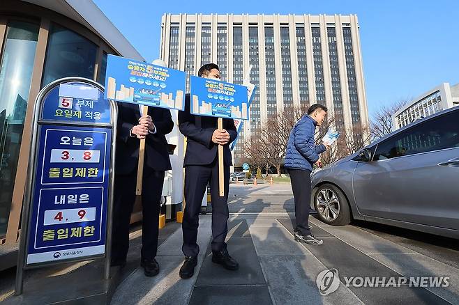 에너지 절약을 위해 (서울=연합뉴스) 이정훈 기자 = 25일 서울 종로구 정부서울청사 입구에서 청사관리소 관계자들이 승용차 5부제 동참 캠페인을 하고 있다. 2026.3.25 uwg806@yna.co.kr