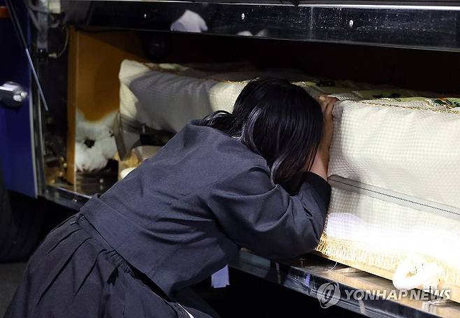 눈물 속 발인식 (대전=연합뉴스) 이주형 기자 = 25일 대전 대덕구 안전공업 화재 참사 희생자의 발인식이 엄수된 가운데, 유가족이 장지로 이동하는 고인의 관을 끌어안고 있다. 2026.3.25 coolee@yna.co.kr