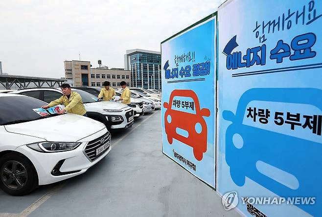 공공부문 승용차 5부제 의무 강화 (광주=연합뉴스) 조남수 기자 = 24일 오후 광주 북구 효죽2주차장 4층에서 구청 에너지정책팀 직원들이 차량 유리창에 승용차 요일제 안내문을 부착하고 있다. 2026.3.24 iso64@yna.co.kr