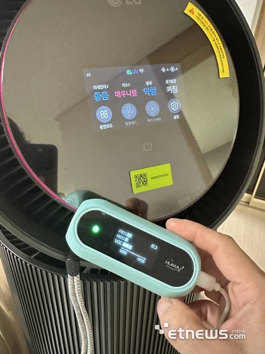 LG 퓨리케어 AI 오브제컬렉션 360° 공기청정기 M7 디스플레이 전면부. 필터 비닐을 벗기지 않은 상태의 실내 TVOC 수치를 TVOC 전용 감지기 수치와 비교하고 있다.
