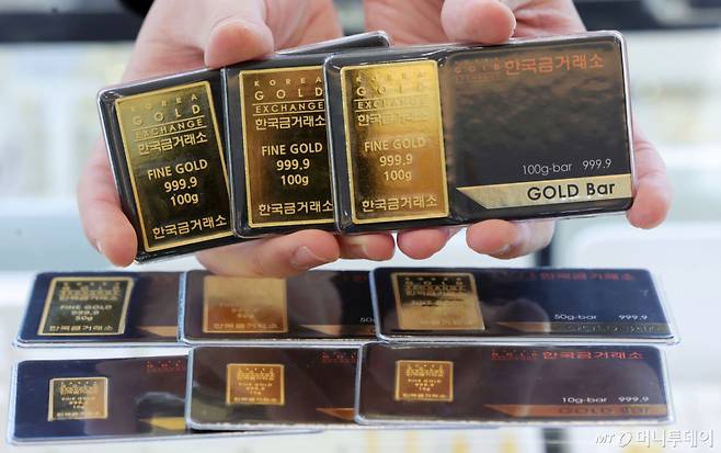 [서울=뉴시스] 홍효식 기자 = 금값이 마침내 '한 돈 100만 원' 선을 넘어선 22일 서울 종로구 한국금거래소 종로본점에서 직원이 골드바를 내보이고 있다.  이날 한국금거래소에 따르면 전일 기준 순금 1돈 매입가는 100만9000원으로 집계됐다.  전 세계적으로 지정학적 불안이 커지는 가운데 그린란드를 둘러싼 미국과 유럽 간 갈등이 급격히 고조되면서 글로벌 금융시장에서 안전자산 선호 심리가 한층 강화된 영향으로 풀이된다. 2026.01.22. yesphoto@newsis.com /사진=홍효식