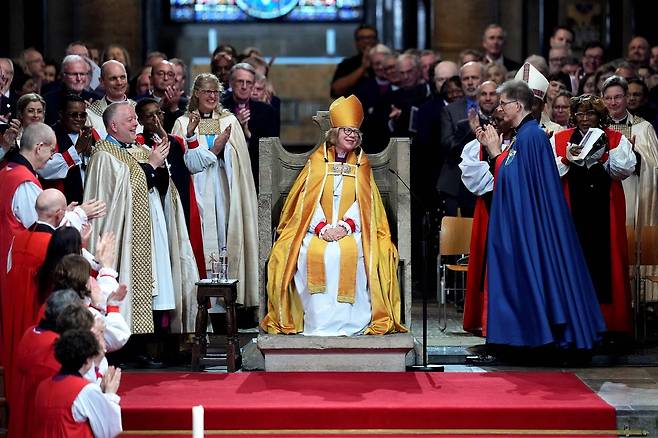 25일(현지시간) 영국 캔터베리 대성당에서 열린 세라 멀랠리 캔터베리 대주교 즉위식에서 성직자들과 신자들이 박수를 치고 있다. AFP 연합뉴스