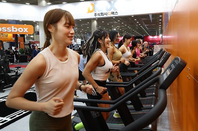 26일 서울 강남구 삼성동 코엑스에서 열린 2026 서울국제스포츠레저산업전에서 참관객들이 참가업체의 기구를 사용해 운동하고 있다. 연합뉴스