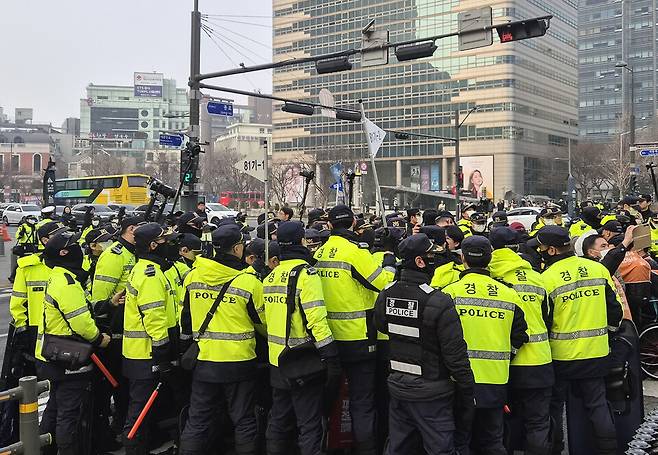 전국장애인차별철폐연대(전장연) 회원들이 3월27일 출근길 서울 종로구 광화문 버스 승강장 인근 횡단보도에서 '탑승 시위'를 벌이자 경찰이 이를 통제하고 있다. ⓒ 연합뉴스