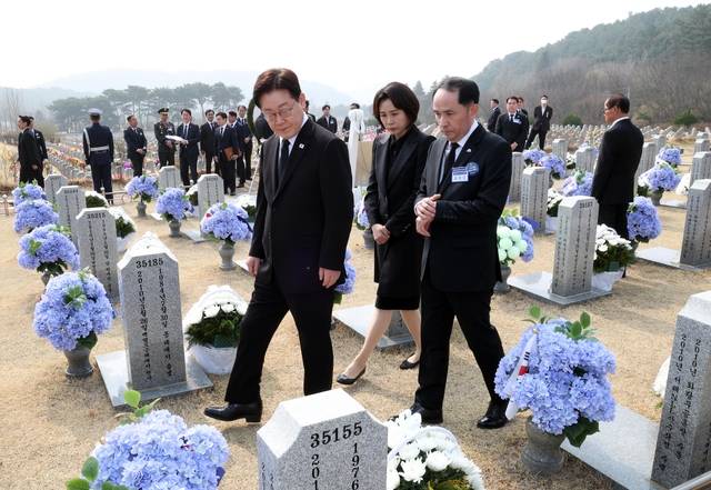 이재명 대통령과 김혜경 여사가 서해수호의 날인 27일 국립대전현충원 천안함 용사 묘역에서 참배 후 묘비를 살펴보고 있다. 연합뉴스