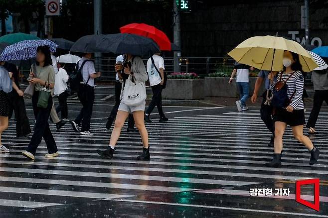 지난해 7월 16일 서울 여의도 버스환승센터에서 직장인들이 우산을 꼭 붙잡고 출근길에 오르고 있다. 강진형 기자