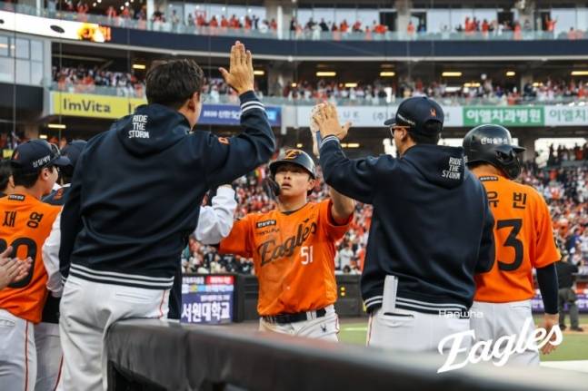 문현빈(가운데)이 득점한 뒤 더그아웃에서 코칭스태프의 환영을 받고 있다. /사진=한화 이글스 제공