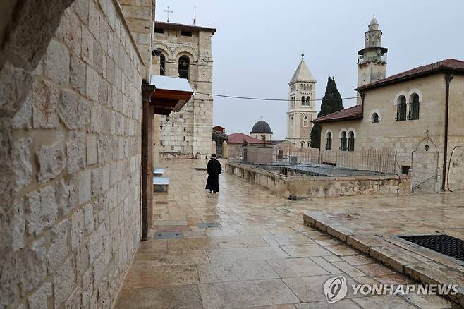 텅빈 성묘교회 인근을 걷는 행인 [로이터=연합뉴스. 재판매 및 DB 금지]