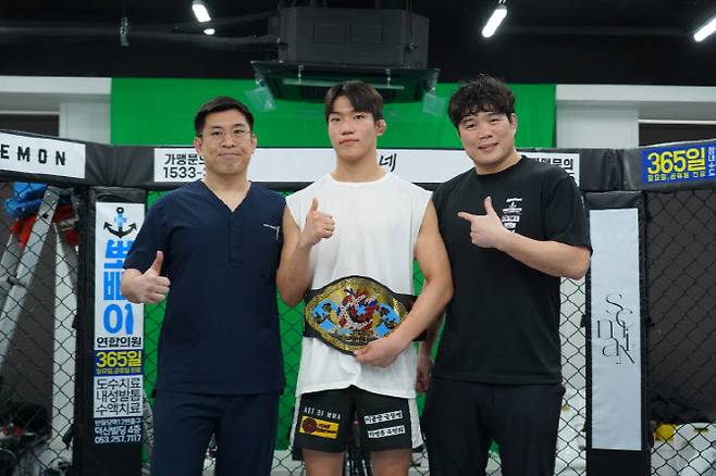 전 KMMA 페더급 챔피언 김지경(가운데)에게 김대환 KMMA 대표(오른쪽)와 메인스폰서 뽀빠이연합의원 김성배 대표원장이 KMMA 명예의 전당 벨트를 시상하고 있다. 사진제공=뽀빠이연합의원KMMA파이터에이전시