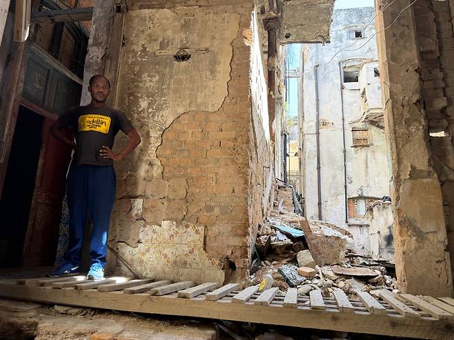 복싱 강사 란디씨가 거의 무너져 가는 아바나 자신의 집 앞에 서 있다. /박국희 특파원