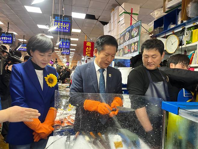 정청래 더불어민주당 대표가 노량진 수산시장의 한 상점을 방문해 칼을 갈고 있다./이건 기자