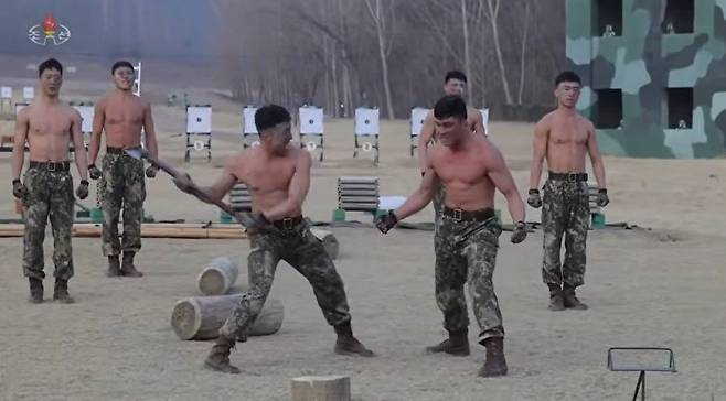조선중앙TV는 29일 전투원들이 김정은 노동당 총비서 앞에서 진행한 시범 장면을 보도했다.  복부 근육으로 도끼를 튕겨내는 모습. 사진=조선중앙TV 캡처