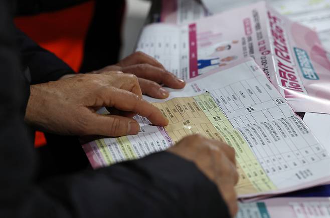 지난해 12월 서울 마포구청에서 열린 노인일자리 박람회에서 어르신들이 참가업체 모집요강을 살펴보고 있다. [뉴스1]