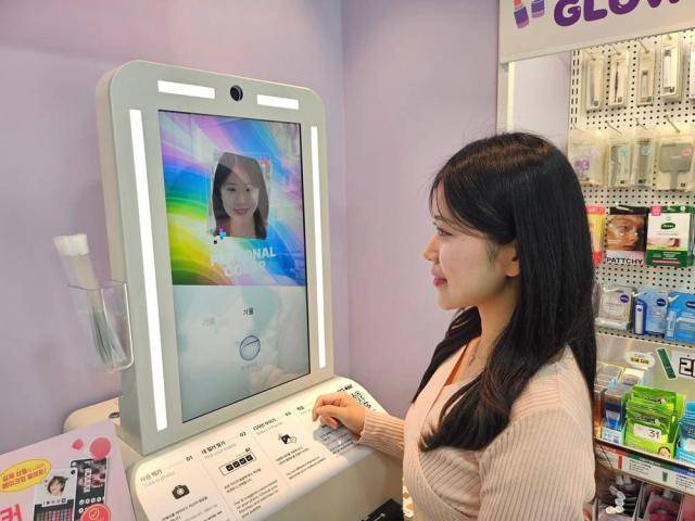 모델이 CU 'AI 메이크업 팔레트 메이커' 키오스크를 사용하고 있다. [사진=CU]