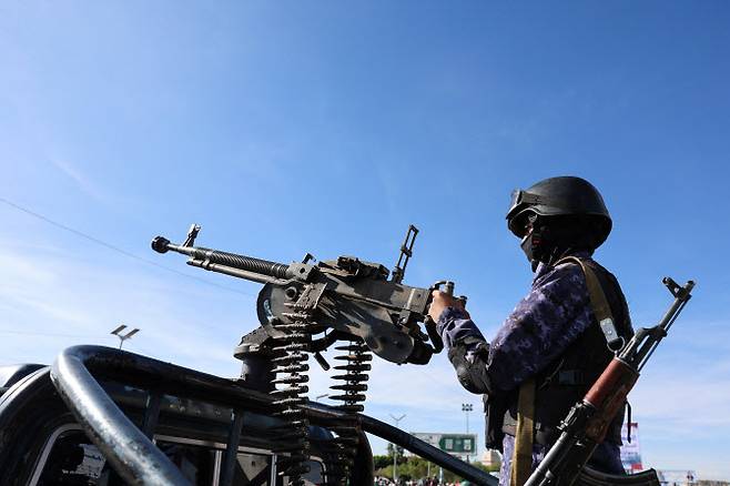 지난 27일(현지시간) 미국·이스라엘과 이란 간 갈등이 이어지는 가운데 예멘 사나에서 열린 이란 지지 집회 현장에서 후티 경찰 대원이 순찰 차량에 장착된 기관총을 운용하고 있다. (사진=로이터)