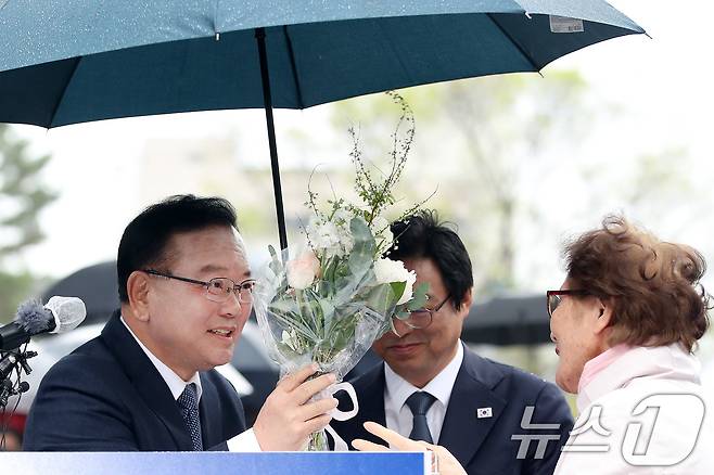 김부겸 전 국무총리가 30일 오후 대구 중구 2·28기념중앙공원에서 6·3지방선거 대구시장 출마를 선언한 뒤 한 시민이 건넨 꽃다발을 받고 있다. 2026.3.30 ⓒ 뉴스1 공정식 기자