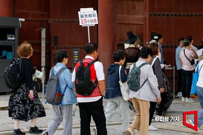 서울 종로구 경복궁에서 중국인 단체 관광객 인솔자가 길을 안내하고 있다. 2025.9.29 강진형 기자