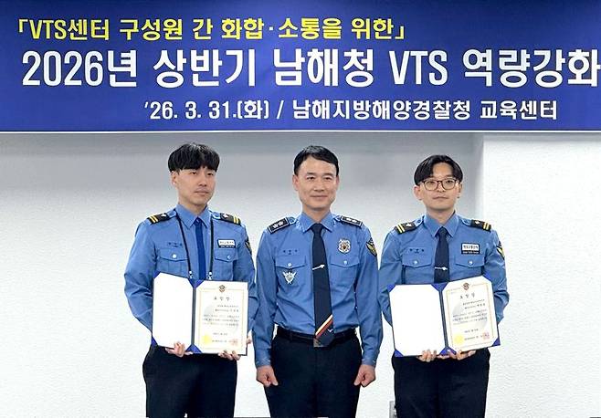 31일 부산 영도구 남해청 교육센터에서 열린 VTS 역량강화 워크숍에서 최우수 관제사로 뽑힌 이상훈 마산항해교통관제센터 해양수산주사보(왼쪽)가 하만식 남해해경청장(가운데)과 기념촬영하고 있다. 남해해경청 제공