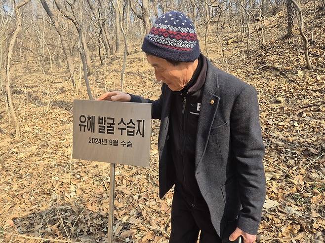 강영구 ‘한국전쟁 전후 민간인 희생자 김천유족회장’이 경북 김천 돌고개에서 ‘유해 발굴 수습지’ 알림판을 만지고 있다. 2024년 9월 희생자 유해 42구가 수습된 곳이다. 서보미 기자