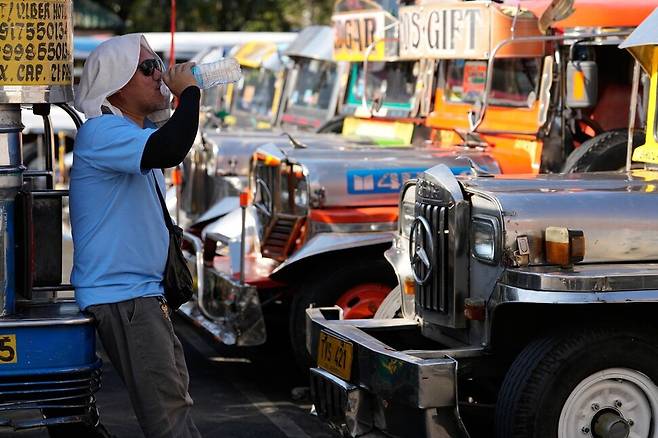 지난 23일 필리핀에서 한 지프니 운전사가 물을 마시고 있다. AP 연합뉴스