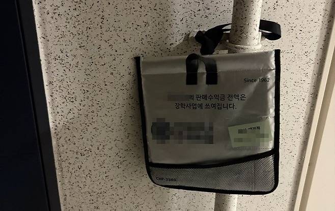 충남 홍성군 홍북읍의 한 아파트 현관 앞에 우유 보관 파우치(주머니)가 매달려 있다. 배달직원은 2~3일 단위로 수거 여부를 확인한 뒤 이를 대리점에 보고한다. [사진 홍북읍행정복지센터]