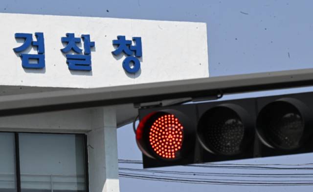 ▲ 올해 10월 수사와 기소 분리 원칙에 따라 검찰청을 폐지하고 기소를 전담으로 하는 공소청신설을 위한 법안의 국회 입법절차가 완료되며 검사 이탈 우려의 목소리가 나오고 있다. 사진은 26일 신호등 빨간불 뒤로 보이는 춘천지방검찰청 모습. 김정호 기자