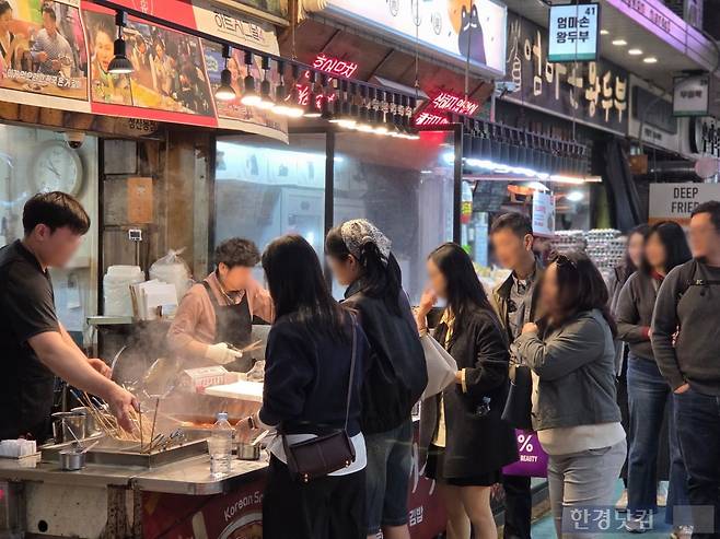 외국인 관광객들이 분식점 앞에서 떡볶이를 구경하고 있다. /사진=이정우 기자