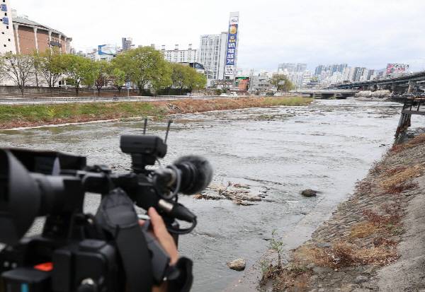 31일 대구 북구 칠성동 잠수교 아래 신천에서 여성의 시신이 담긴 캐리어가 발견된 가운데 캐리어가 발견된 지점에서 취재진이 취재하고 있다. 연합뉴스