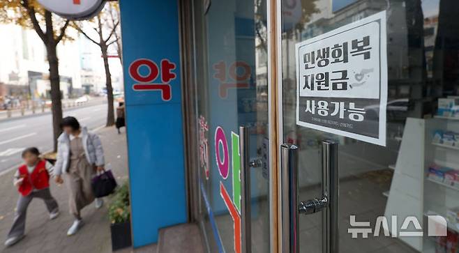 [서울=뉴시스] 김선웅 기자 = 30일 서울 시내의 상점가에 민생회복 소비쿠폰 사용 가능 안내문이 붙어 있다. 2025.11.30. mangusta@newsis.com