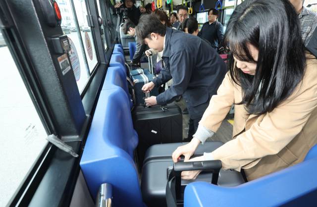 1일 오후 부산 영도구 청학동 유한여객 차고지에서 열린 ‘시내버스 대형 캐리어 반입 시범 사업 시연회’에서 참석자들이 대형 캐리어를 버스 내에 결착하고 있다. 정종회 기자 jjh@