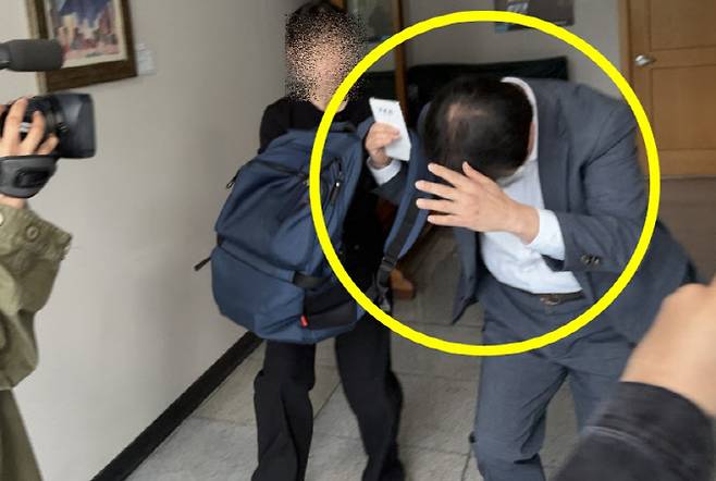 식당 공용 화장실에 소형 카메라 여러 대를 설치해 불법 촬영을 시도한 충북도교육청 소속 장학관이 1일 구속 전 피의자 심문(영장실질심사)을 받으러 가며 취재진을 필사적으로 피하고 있다. (사진=연합뉴스)