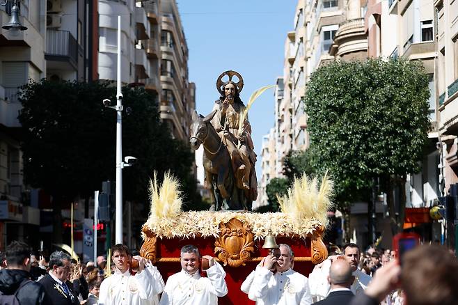 3월 29일, 스페인 알리칸테주 엘체에서 열린  종려주일 행렬에서 카톨릭 교도들이 나귀 탄 예수상을 끌고 행진하고 있다./EPA 연합뉴스