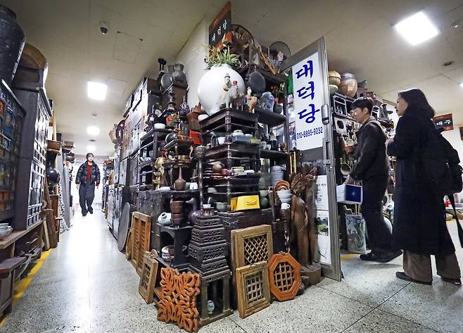 People browse antiques in front of a shop at the Dapsimni Antique Shopping Mall on March 11. [PARK SANG-MOON]