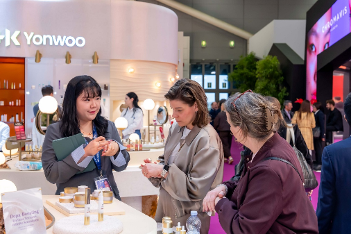 ‘코스모프로프 볼로냐 2026’에 참석한 바이어들이 한국콜마 부스에서 스킨케어 제품들을 직접 발라보는 등 체험하고 있다. [한국콜마]