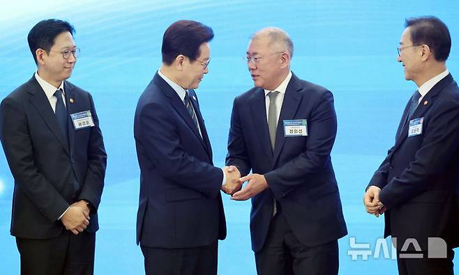 [군산=뉴시스] 최동준 기자 = 이재명 대통령이 27일 전북 군산 새만금컨벤션센터에서 열린 '새만금 로봇·수소·AI시티 투자협약식'에서 기념촬영을 마친 뒤 정의선 현대자동차그룹 회장과 악수하고 있다. (청와대통신사진기자단) 2026.02.27. photocdj@newsis.com
