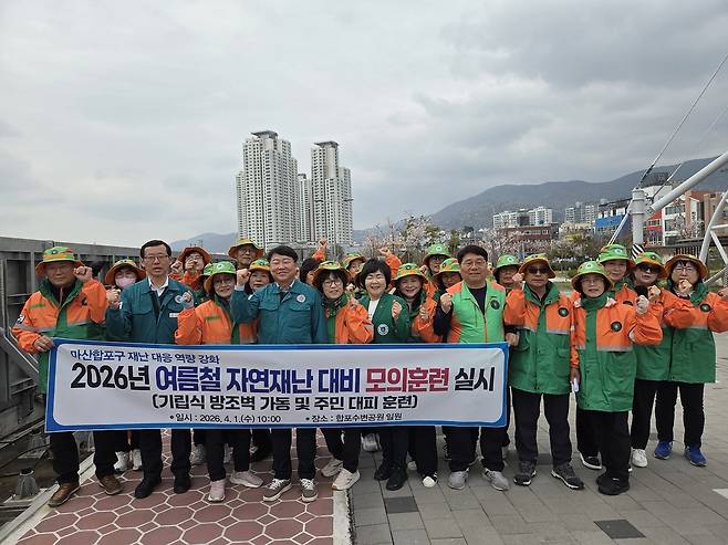 기립식 방조벽 가동 훈련 실시 (창원=연합뉴스) 1일 오전 경남 창원시 마산합포구 합포수변공원 일원에서 구청 공무원과 자율방재단이 기립식 방조벽(왼쪽) 가동 훈련을 실시한 뒤 기념촬영을 하고 있다. 2026.4.1 [창원시 제공. 재판매 및 DB 금지]