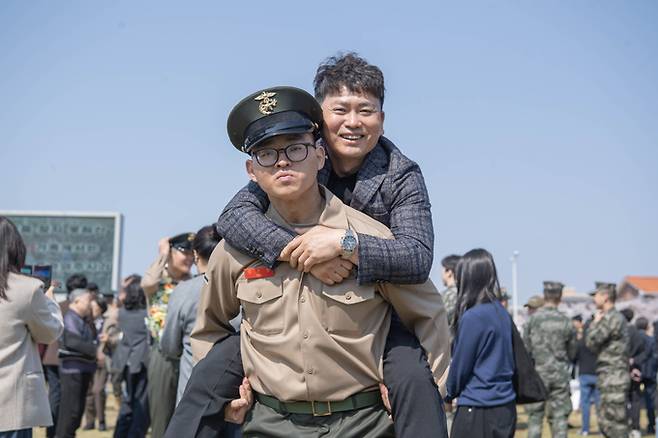 ▲ 2일 열린 해병신병 1327기 수료식에서 해병대 최초 4대 해병 가족이 된 김준영 이병이 3대 해병인 아버지 김철민씨를 업고 기념촬영한 모습. 해병대교육훈련단 제공