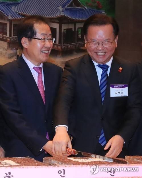 자유한국당 홍준표 대표(왼쪽)와 김부겸 행정안전부 장관이 2018년 1월8일 서울 태평로 한국프레스센터에서 열린 재경 대구-경북인 신년교례회에서 함께 칼을 잡고 축하떡을 자르며 미소짓고 있다. 연합뉴스