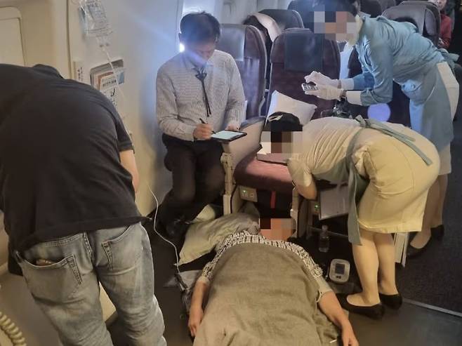 지난달 24일 비행기에서 김정환 강남을지병원 교수 등이 응급조치를 하고 있는 모습. 김정환 강남을지대병원 교수 페이스북 캡처