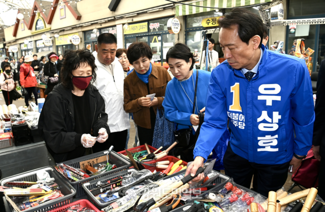 ▲ 우상호 더불어민주당 강원도지사 예비후보와 우 후보의 부인 이현주씨가 2일 춘천 풍물시장에서 농기구를 구매하고 있다. 방도겸 기자