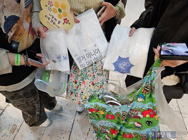 2일 오후 2시경 서울 강남구 코엑스에서 열린 '2026 서울국제불교박람회'에서 정유진(37) 씨와 함께 온 친구들이 구매한 굿즈를 보여주고 있다. / 사진=박수빈 기자