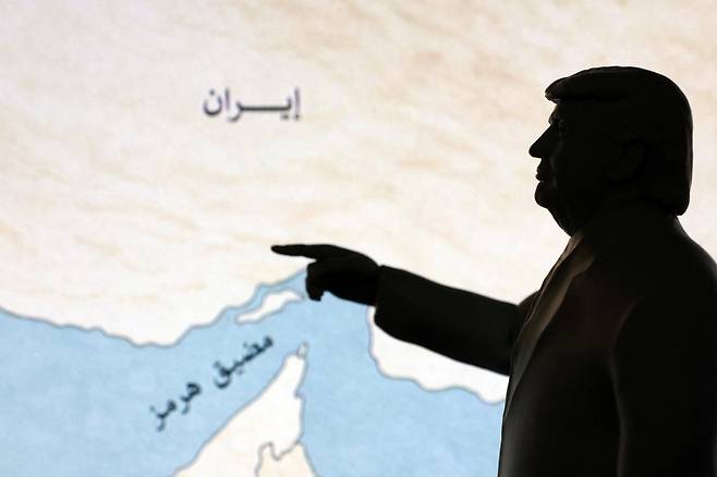 A 3D-printed miniature model depicting U.S. President Donald Trump and map showing the Strait of Hormuz, also known as Madiq Hurmuz, are seen in this illustration taken March 26. [REUTERS/YONHAP]