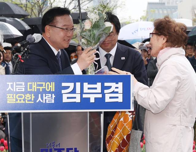 ▲더불어민주당 소속 김부겸 전 국무총리가 30일 오후 대구 중구 동성로 2·28기념중앙공원에서 대구시장 선거 출마를 밝히던 중 한 시민으로부터 꽃다발을 받고 있다. ⓒ연합뉴스